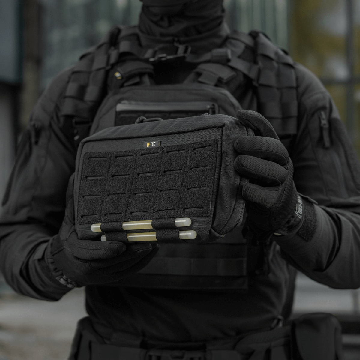 Taktisk operatør holder en M-Tac Admin Pouch Large Elite, perfekt til opbevaring af taktisk udstyr og dokumenter, fremstillet af Cordura 500D.