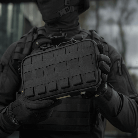 Person håller M-Tac Admin Pouch Large Elite i svart, funktionell väska för taktisk utrustning tillverkad av Cordura 500D med velcro och Laser Cut-utskärningar.
