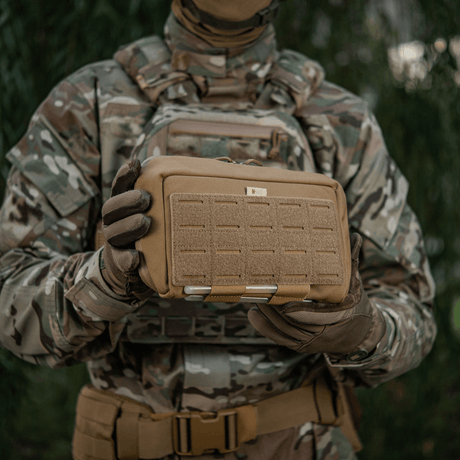 M-Tac Admin Pouch Large Elite, taktisk utrustning i camouflagedräkt, hålls av soldat i fältutrustning.