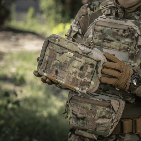 M-Tac Admin Pouch Large Elite hålls av person i kamouflagemundering, visar hållbar och funktionell design med velcro-paneler för taktisk användning.
