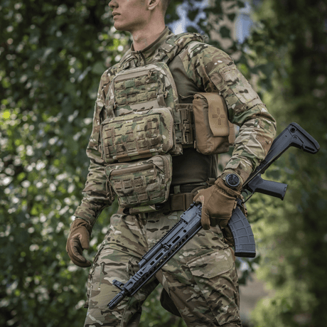 Person i camouflageuniform bär M-Tac Admin Pouch Large Elite och håller ett taktiskt gevär i skogen.