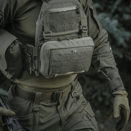 M-Tac Admin Pouch Large Elite buren av person med taktisk utrustning i naturen, visar funktionell förvaring och hållbarhet.