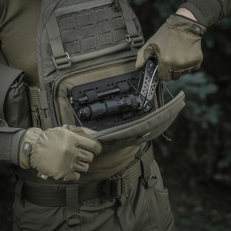 Person öppnar M-Tac Admin Pouch Large Elite med taktisk utrustning, tillverkad av slitstarkt Cordura 500D, lämplig för utomhusbruk.
