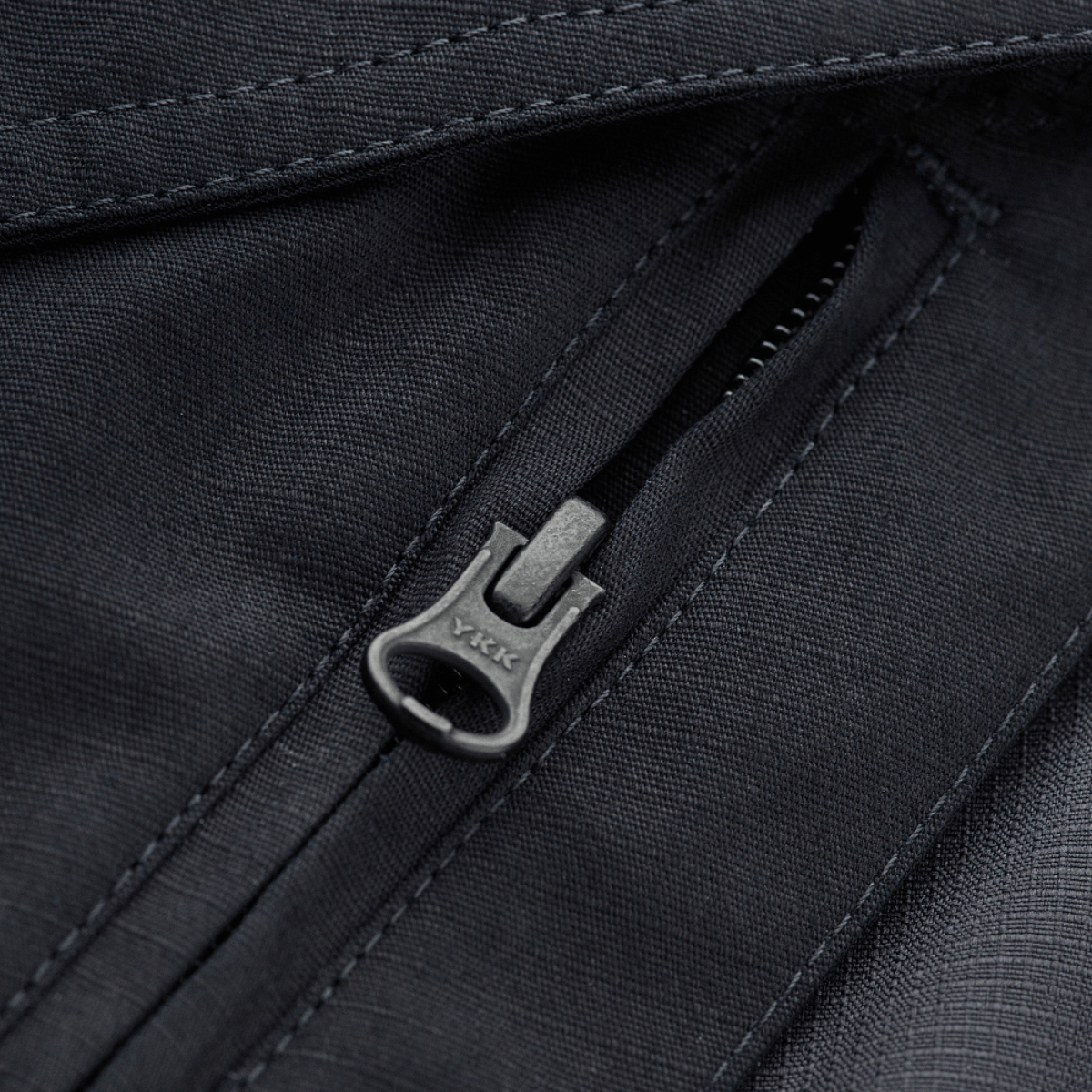 Detalje af M-Tac Shorts Aggressor Gen.II Flex lynlås i vand- og smudsafvisende rip-stop materiale.