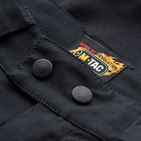 M-Tac Shorts Aggressor Gen.II Flex, close-up på holdbare knapper og logo på rip-stop materiale med Teflon-belægning. Perfekt til træning og fritid.