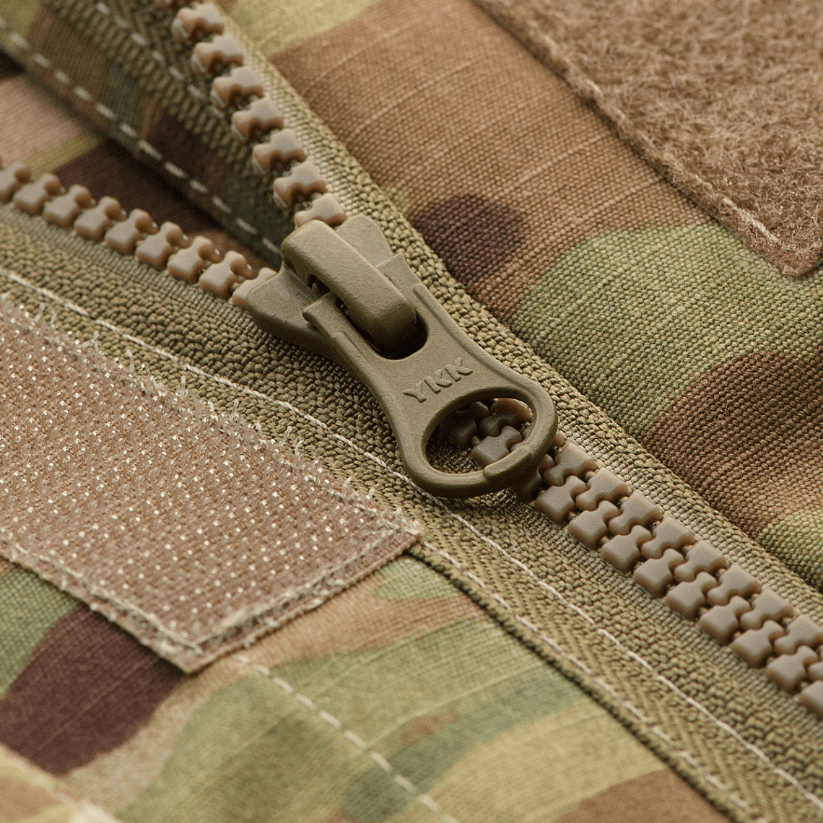 Detaljeret billede af M-Tac Jakke Military Elite NYCO lynlås i MultiCam-design med YKK-lynlås og Velcro-detaljer