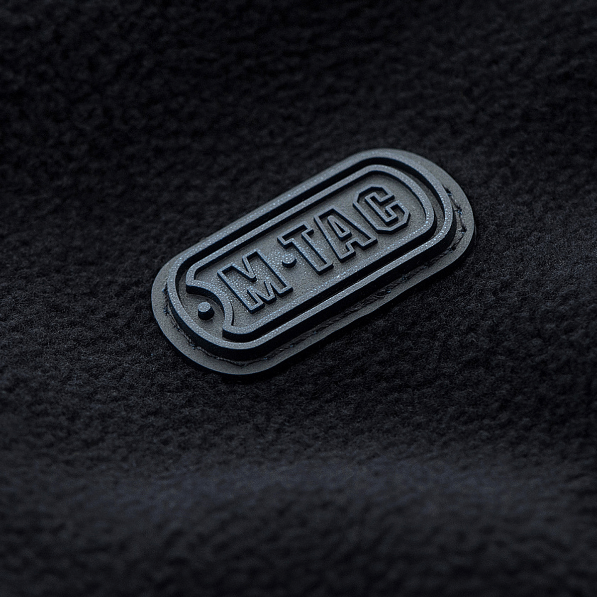 M-Tac logo på microfleece stof af M-Tac Lite Microfleece Hættetrøje, der viser premium skræddersyning og stil.