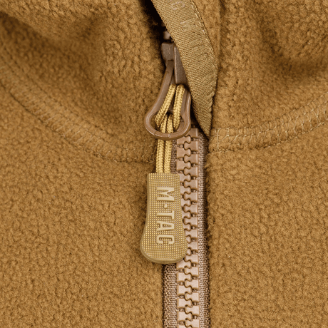 Nærbillede af lynlås på M-Tac Lite Microfleece Hættetrøje med M-Tac-logo, der viser detaljer i det åndbare og elastiske materiale.