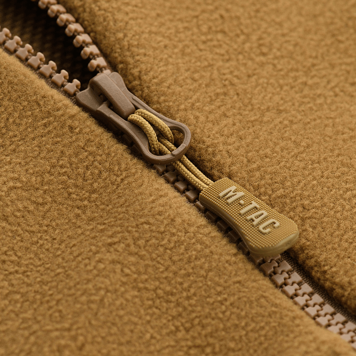 Close-up af lynlås på M-Tac Lite Microfleece Hættetrøje i brun mikrofleece-materiale, fremhæver detalje og mærke