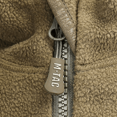 Nærbillede af M-Tac Lite Microfleece Hættetrøje lynlåstønder i brun fleece med M-Tac-logoet.