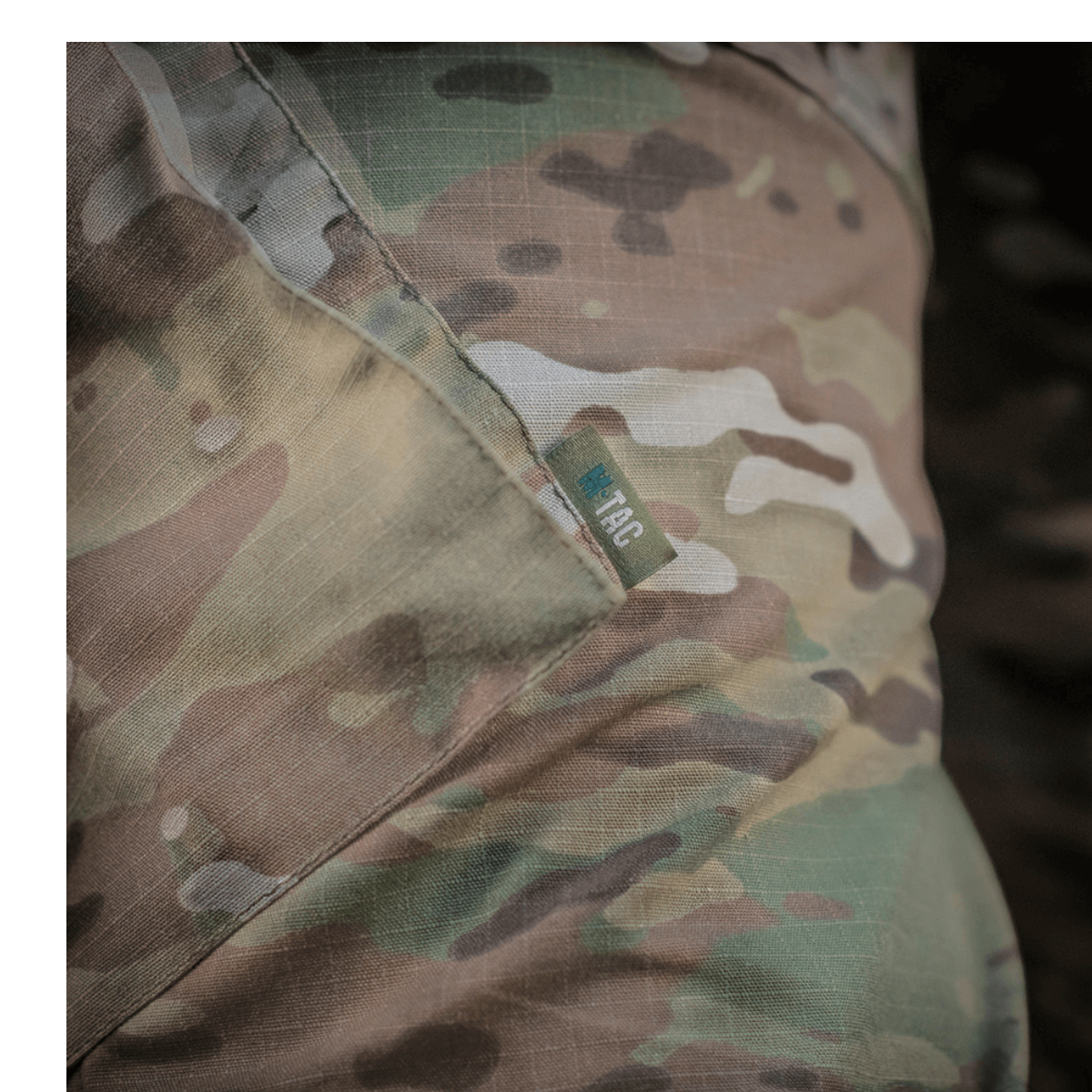 Detalje af M-Tac Feltbukser NYCO i camouflage, lavet af NYCO-stof til holdbarhed og åndbarhed, med kvalitets YKK fittings.