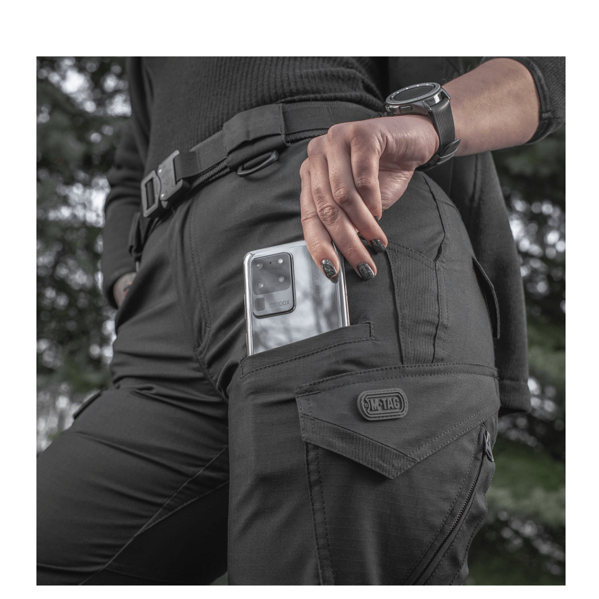 M-Tac Bukser Aggressor Dame Flex i aktion med en telefon i lommen, designet til træning og rejser, innovative og vandafvisende.