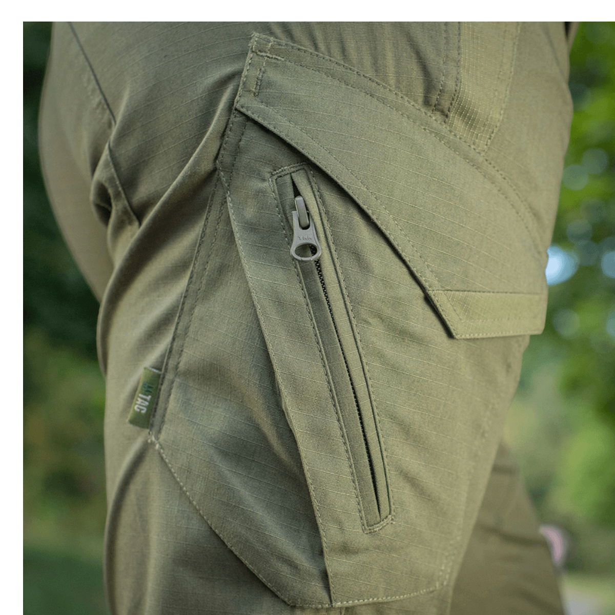 Nærbillede af M-Tac Bukser Aggressor Dame Flex med glat, teflon-impregneret materiale og lynlåsdetaljer, ideel til udendørs brug.