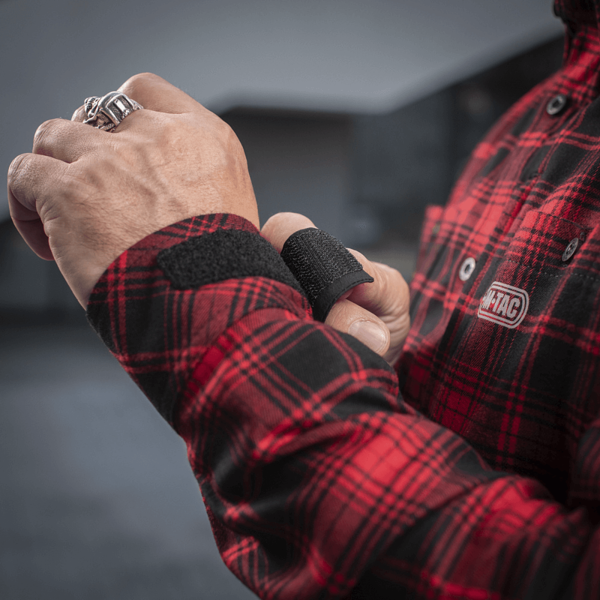 M-Tac Redneck Skjorte i rød plaid mønster med justerbare ærmer, vist på en person med velcro lukning i fokus.