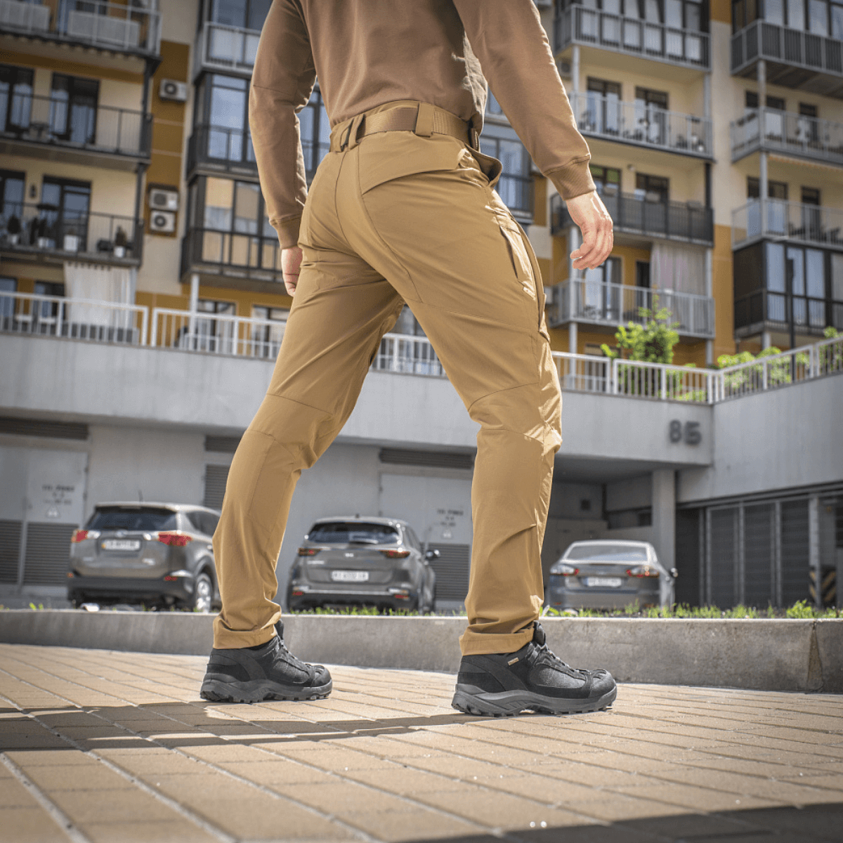 Mand bærer M-Tac Bukser Rubicon Flex på gaden, viser bevægelsesfrihed med 4-Way Stretch stof og innovativ cargo-lomme design