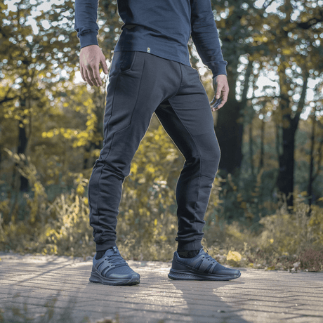 Mand iført M-Tac Bukser Stealth Cotton til løb og hverdag. Bomuldsstof, elastik i taljen, sidelommer. Perfekte til sport og komfort.