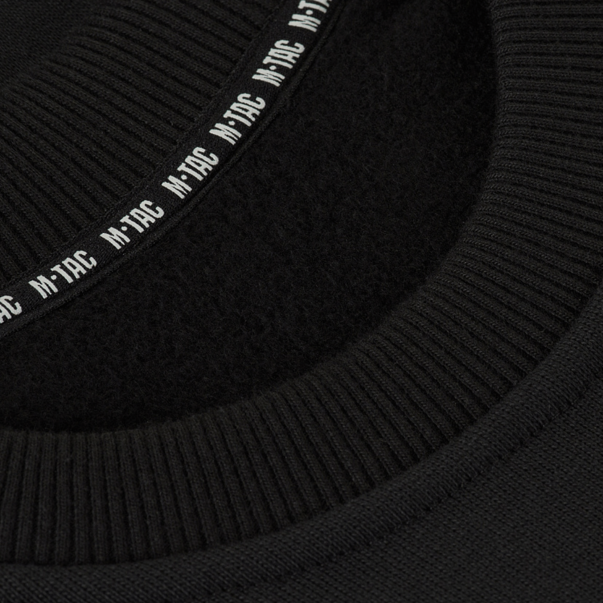 Detalje af M-Tac Sweatshirt Cotton Hard viser ribkant og reflekterende logo på sort 100% bomuldsmateriale, 390 g/m² tæthed.