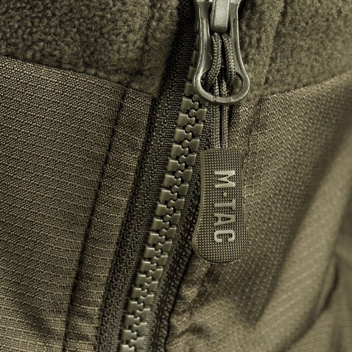 Detalje af lynlås på M-Tac Alpha Microfleece Jakke Gen.II med fokus på holdbar konstruktion og taktisk design.