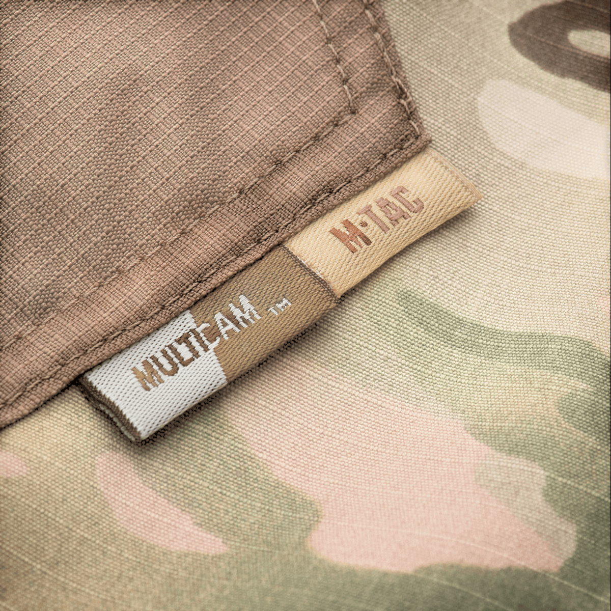 M-Tac Bukser Aggressor Elite NYCO med slidstærk rip-stop stof i multicam print fra M-Tac brandet, der vises tættere på.