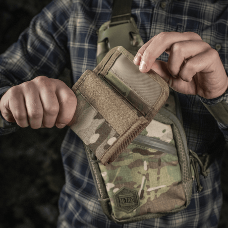 Person håller M-Tac Plånbok Elite Gen.II i Cordura 500D med M-Tac-logotyp och YKK-dragkedjor. Idealisk för kort, sedlar och mynt.