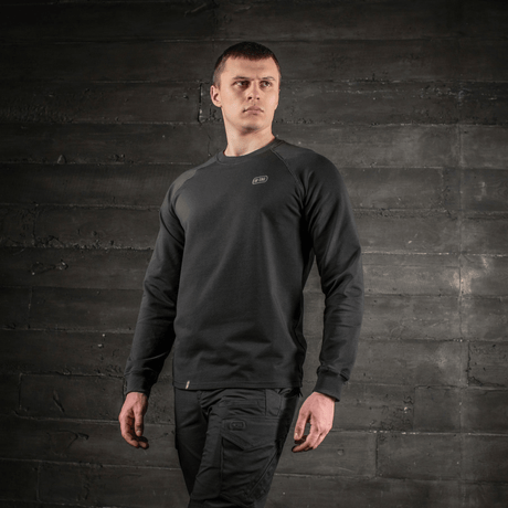 Man bär M-Tac Raglan Athlete i svart med raglanärmar för optimal rörelse, mångsidig sweatshirt för sport och vardag, sedd framifrån