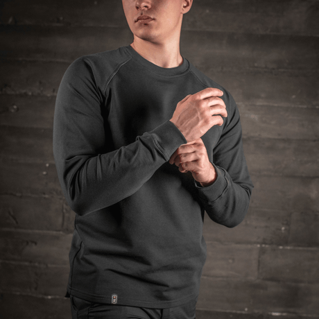 Man i M-Tac Raglan Athlete sweatshirt med rund hals och raglanärm i svart, idealisk för sport och vardag.
