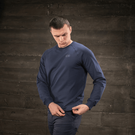 Man i M-Tac Raglan Athlete sweatshirt i mörkblå med raglanärm och rund hals för optimal rörelsefrihet.