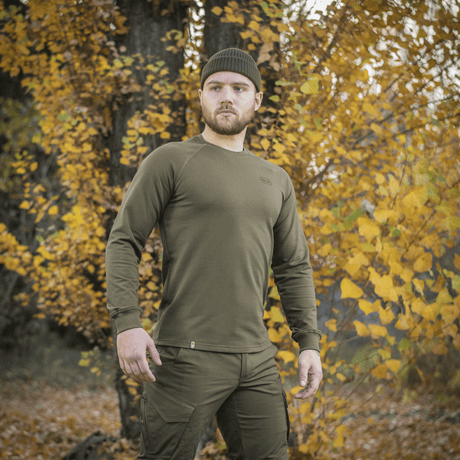 Man i M-Tac Raglan Athlete sweatshirt i olivfärg på hösten.