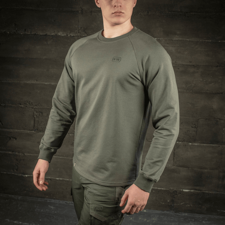 M-Tac Raglan Athlete i olivfärg med raglanärmar och rund hals, perfekt för sport och vardagsbruk, buren av modell.
