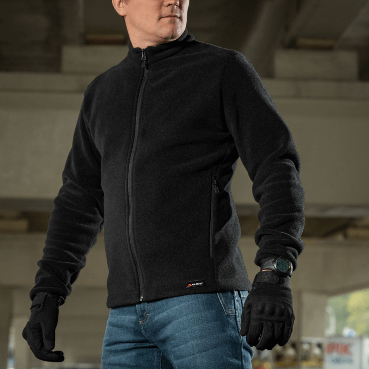 Mand iført M-Tac Nord Polartec Fleecejakke under bro, viser stil og funktionalitet.