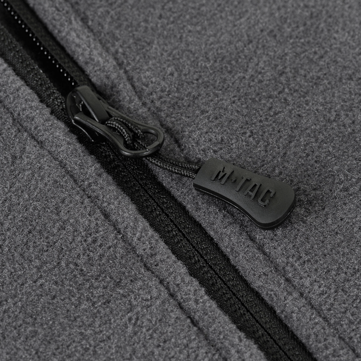 Nærbillede af grå lynlås på M-Tac Nord Polartec Fleecejakke, fremhæver kvalitet og stil.