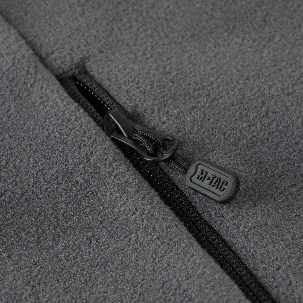 Nærbillede af lynlås på M-Tac Nord Polartec Fleecejakke, fremstillet af premium Polartec® 200 Series fleece, viser detaljeret design.