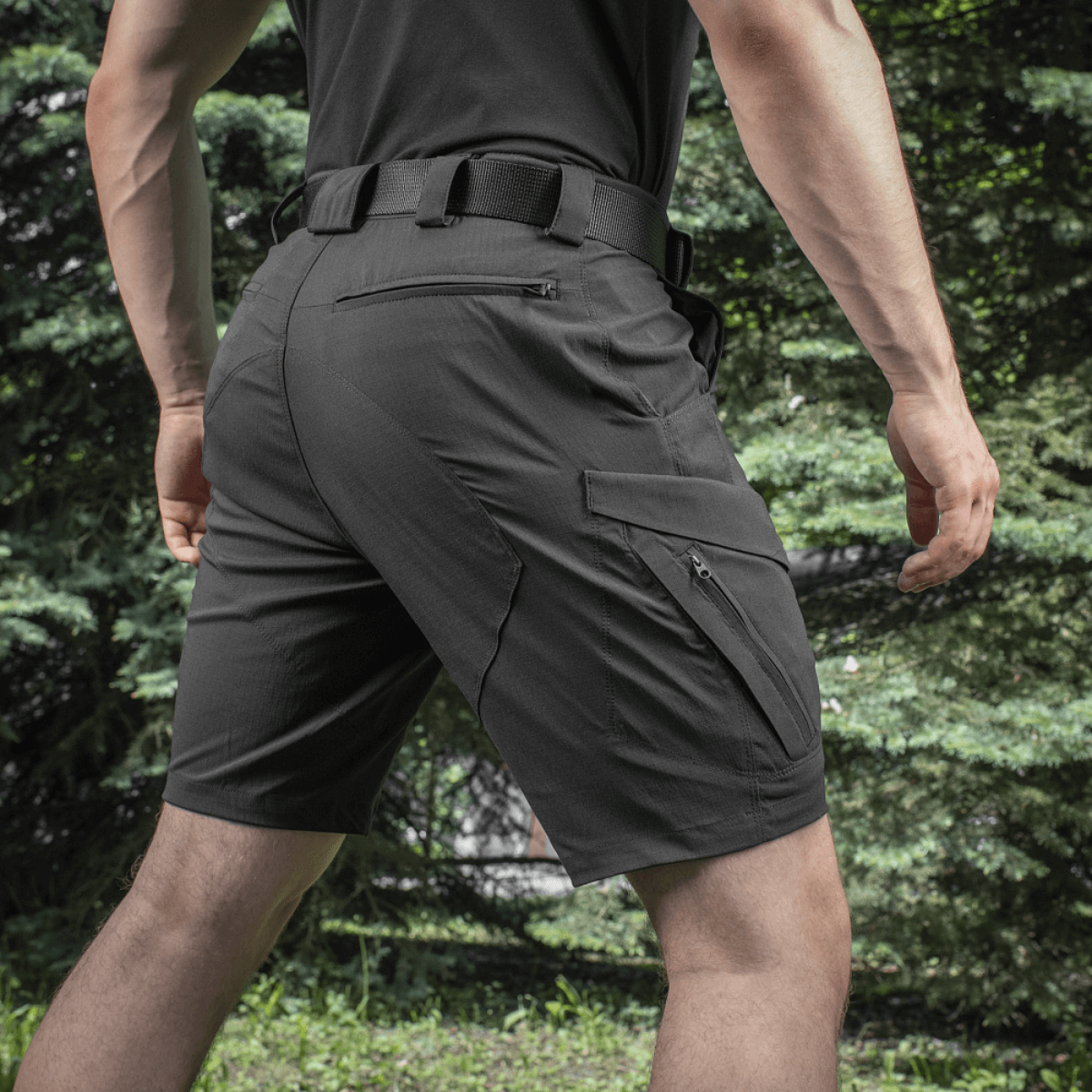 Mand iført M-Tac Aggressor Summer Flex Shorts udendørs, fremhæver de taktiske funktioner og lommedesign.