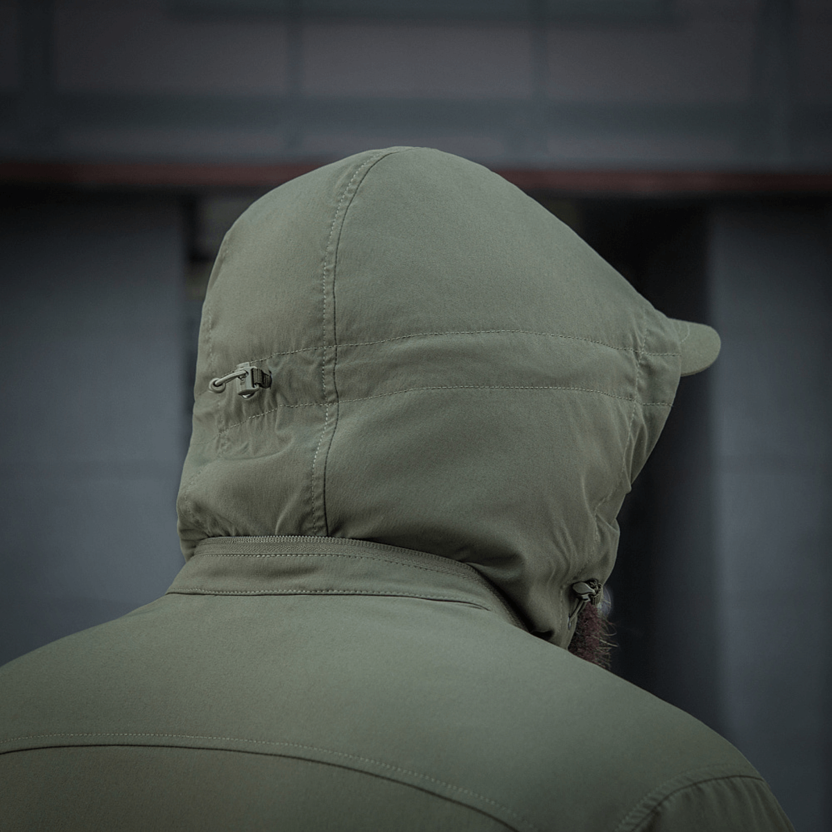 M-Tac Flash Jakke i olivengrøn farve set bagfra med justerbar hætte, ideel til vandreture og aktiv brug i al slags vejr.
