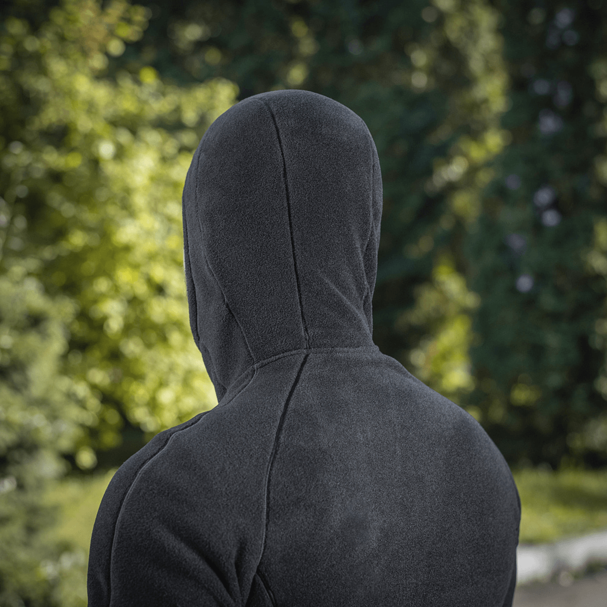 M-Tac Sprint Fleece Sweatshirt Polartec set bagfra i en udendørs omgivelser, fremhæver det stilrene design og Polartec fleece-materiale.