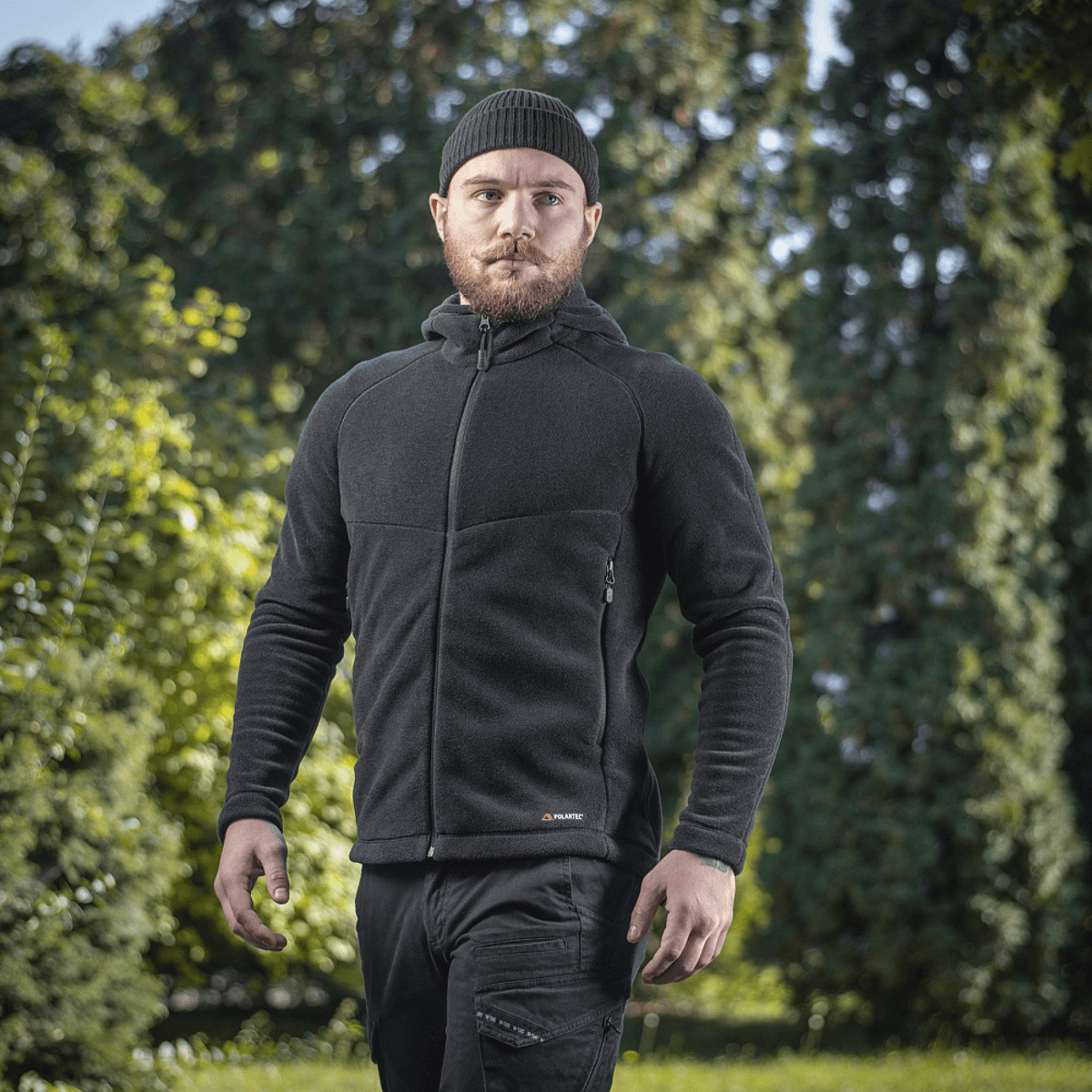 Mand iført M-Tac Sprint Fleece Sweatshirt Polartec i naturlig udendørs omgivelser med grønne træer