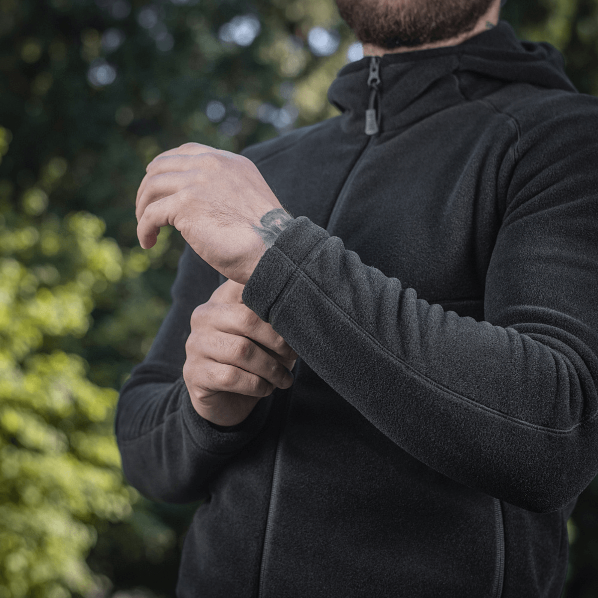 M-Tac Sprint Fleece Sweatshirt Polartec i aktion udendørs, viser blød og holdbar Polartec 200 fleece med justerbar hætte.