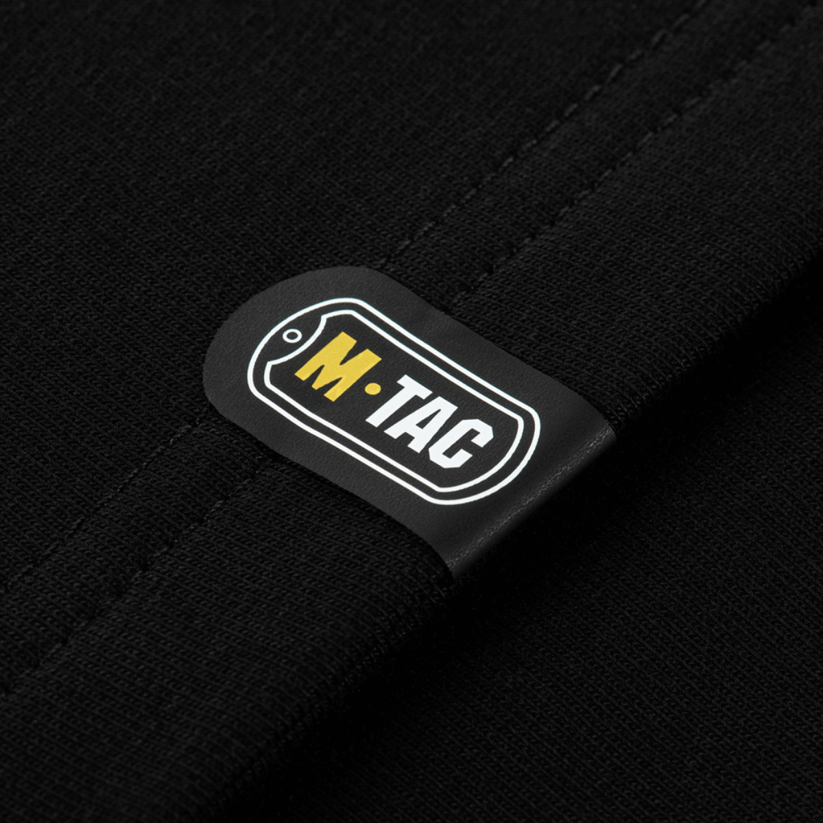 M-Tac logo på sort stof detalje fra M-Tac Raglan Odin Mystery trøje, nordisk design, høj komfort og stilfuld pasform.