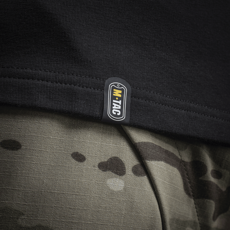 Detalje af M-Tac Raglan Odin Mystery med tydeligt M-Tac logo, sort kant på sejlrib, kombineret med camouflageprint bukser.