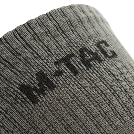 Nærbillede af M-Tac Høje Sokker Mk.2 med fokus på logo, designet til komfort og støtte under trekking og intens aktivitet