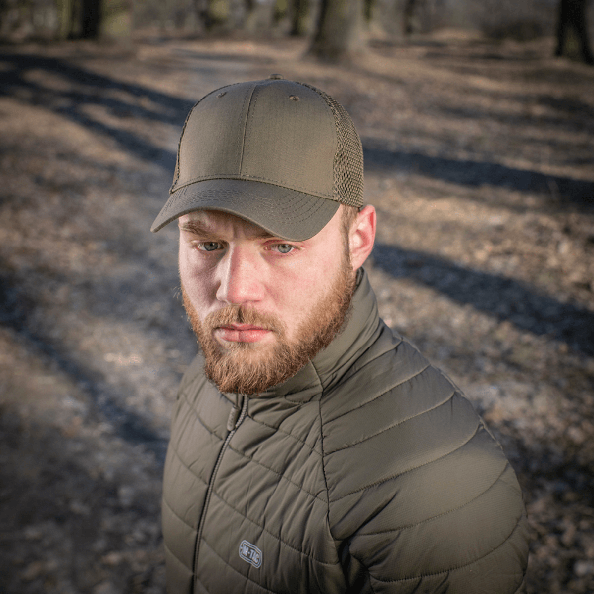M-Tac Mesh Flex Ripstop Baseball Cap båret af en mand i skovmiljø, praktisk til udendørs brug.