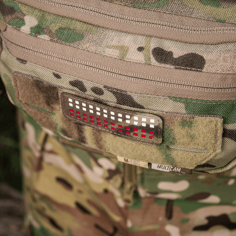 M-Tac Patch Flag 25x80 Mini Squares med laserskuren design på plagg av Cordura 500D med velcrofäste, kamouflagebakgrund.