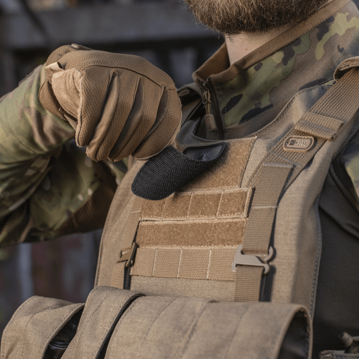 Soldat med M-Tac Spartan Hjelm Patch på vest, viser tapperhed og styrke, lavet af Cordura 500D for holdbarhed, 70x80 mm med velcro.