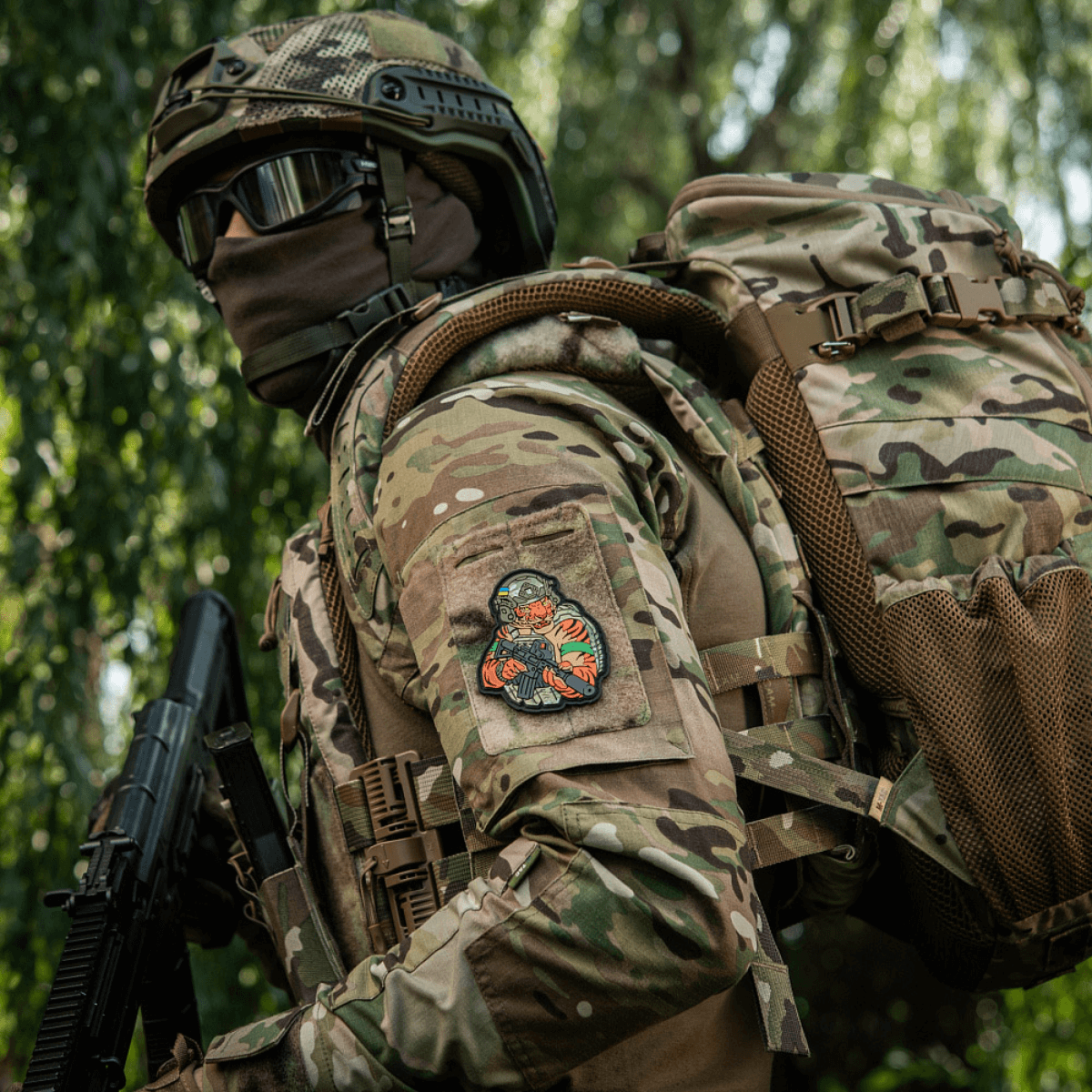 Soldat bærer M-Tac Patch Tiger Green Tape PVC på uniform, viser patriotisk tiger med AR-15. 3D morale patch til udstyr og tøj.