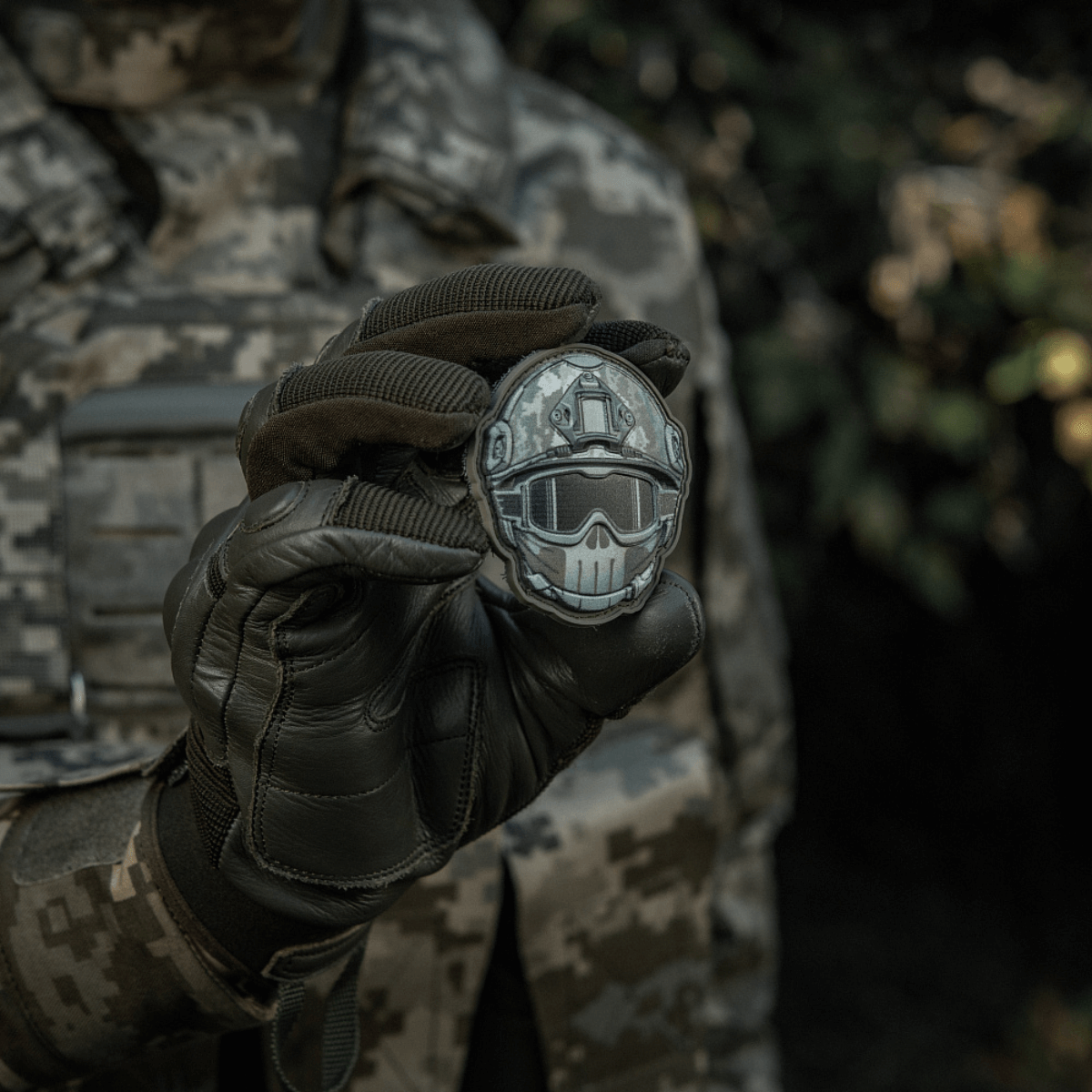 M-Tac Patch Emoji #20 med 3D-effekt, PVC og velcro, holdt af person i camouflage-outfit. Perfekt til tøj, taske, taktisk udstyr.