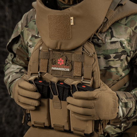 Taktisk utrustning med M-Tac Patch Viking Evac visad på kamouflageuniform.