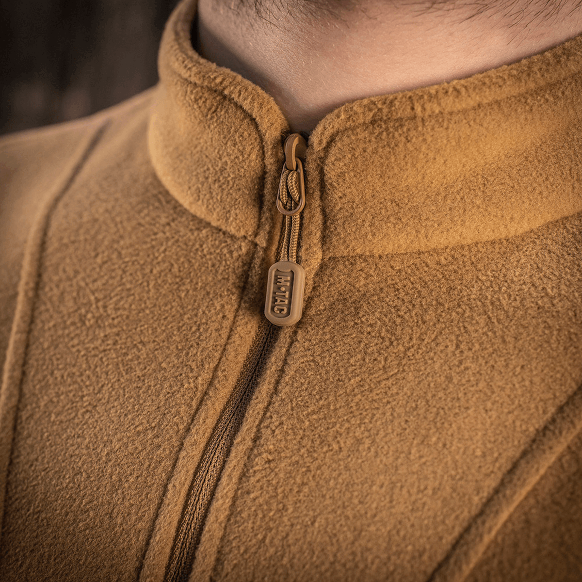 Nærbillede af M-Tac Delta Polartec Fleecejakke i brun farve, der viser lynlås og blødt Polartec® materiale.