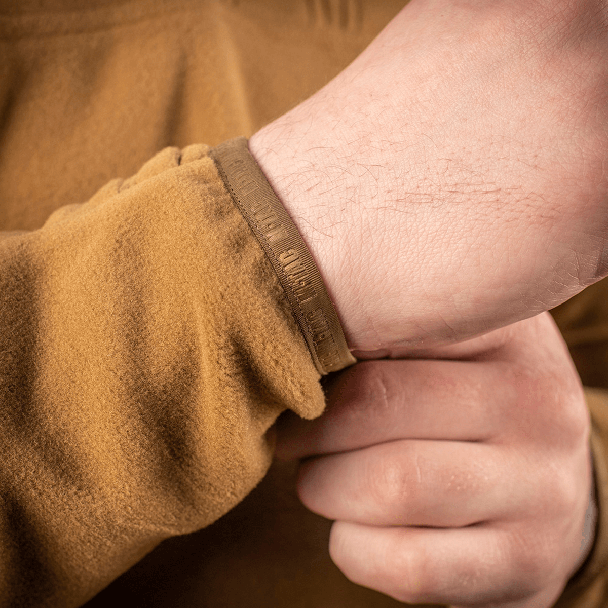 En person i M-Tac Delta Polartec Fleecejakke viser jakkens manchet detaljer. Fremhæver stil og funktionalitet i fleece materialet.