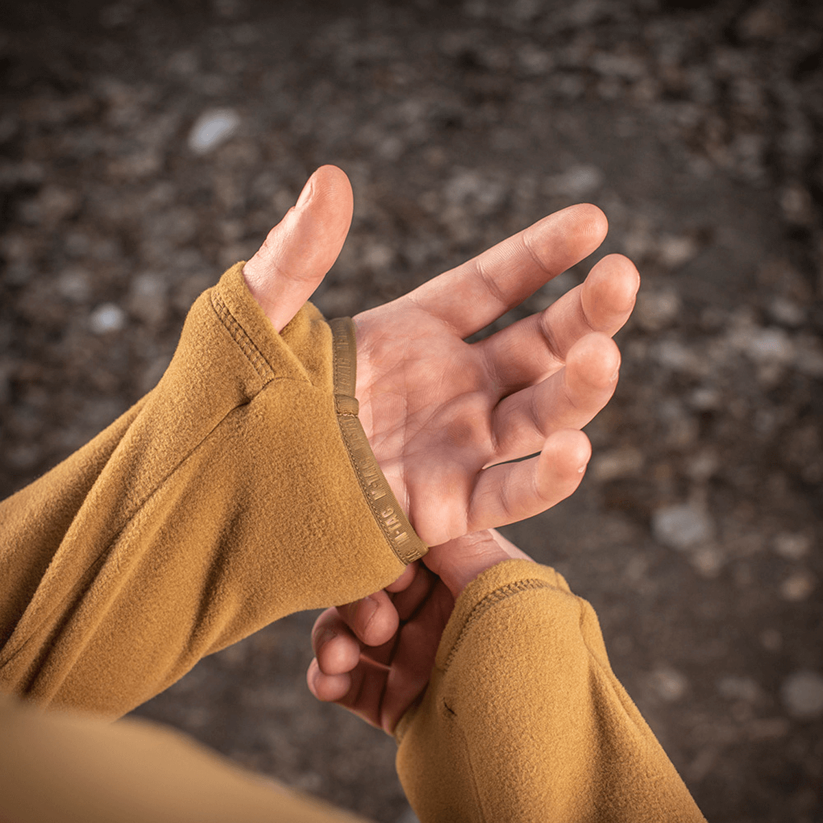 Person iført M-Tac Delta Polartec Fleecejakke der justerer ærme manchetter. Ideel til kolde dage med åndbart Polartec® Micro Series-fleece.