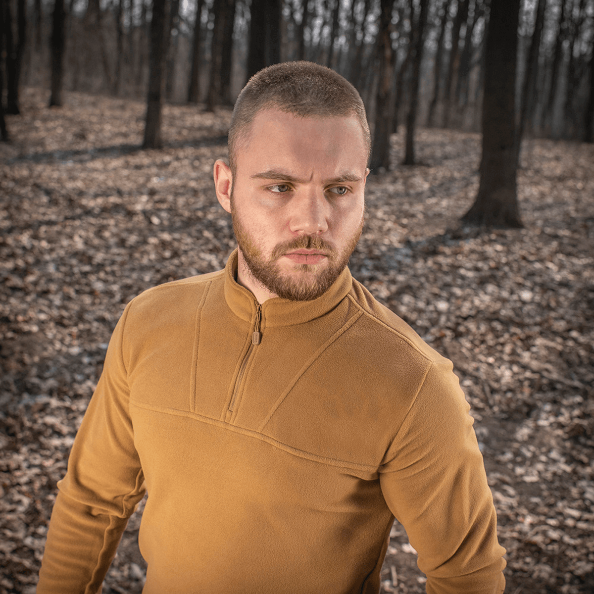 Mand iført M-Tac Delta Polartec Fleecejakke i en skov, viser stilrent og funktionelt design, ideel til kolde dage.